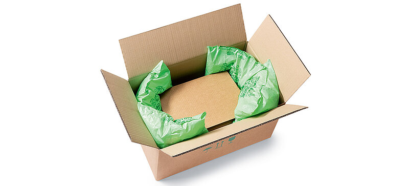 A box with a box inside padded with plastic bags with packing chips