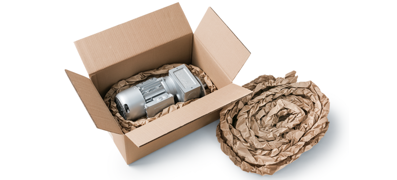 A cardboard box containing an engine component and brown paper cushioning