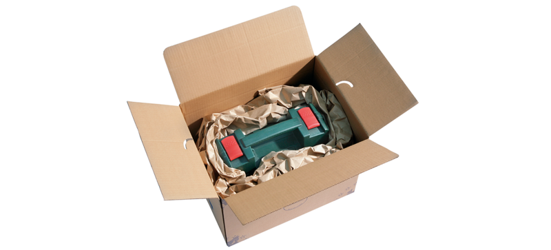 A cardboard box containing a toolbox and brown paper cushioning