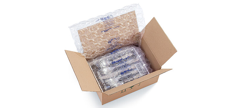 A cardboard box containing a cutlery set and air cushions