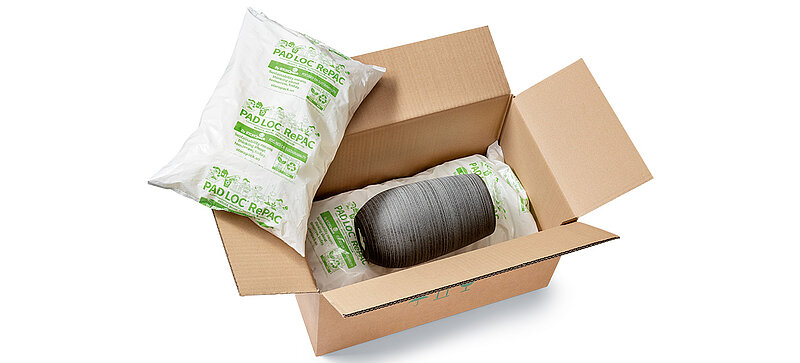 A box containing a vase padded with plastic bags with packing chips
