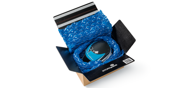 A cardboard box containing a helmet and blue air cushions