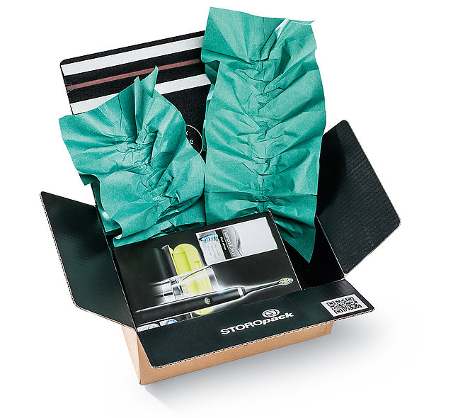 Ein Karton mit einem Produkt und grünen Papierpolstern