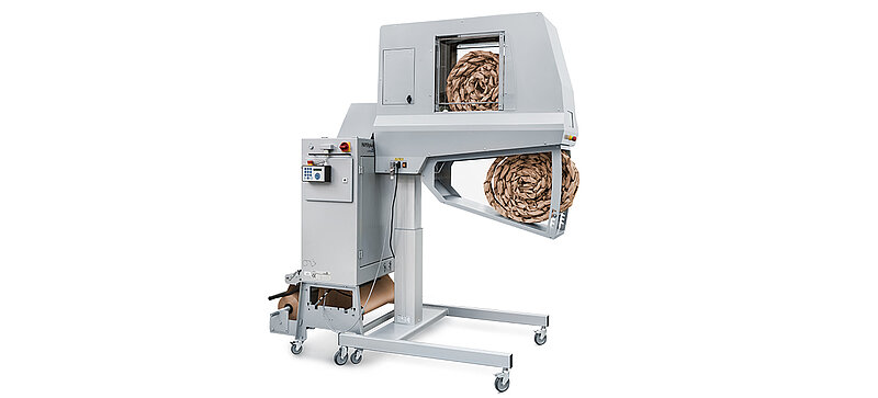 A gray machine making brown paper cushioning strips